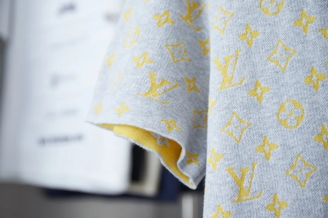 🅿️200 1V / MONOGRAM Short-sleeved crew neck shirt This crew neck shirt is made of soft cotton, which can inject colorful vitality into the summer look. The full-width Monogram Glow jacquard and the elegant background collide with color contrast, making the Monogram pattern reflect the subtle sheen of mulberry silk.  14S yarn not only maintains the delicate feel of the fabric, but also ensures sufficient strength and durability. The blended material combines the comfort and breathability of cotton with the softness, luster and premium feel of mulberry silk. Cotton fiber provides good moisture-wicking properties, while mulberry silk provides a smoother feel.  The addition of jacquard patterns makes this piece of clothing more visually appealing and becomes a highlight that enhances the overall look.  The technical characteristics of the sesame base jacquard cylindrical woolen short-sleeves are mainly reflected in its selected materials, unique weaving technology, rich design elements and excellent wearing experience. These features make this short-sleeved garment not only fashionable, but also very practical and comfortable. S M L XL